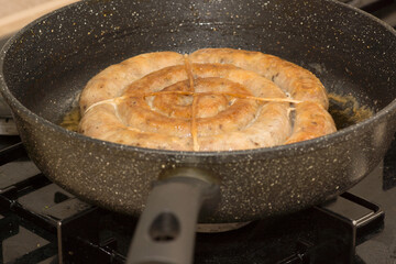 sausage is fried in a frying pan