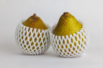 緩衝材（フルーツキャップ）付きのラ・フランス、白背景