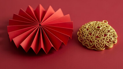 Red paper fan beside intricate golden ornament