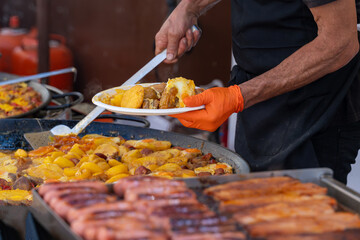 Street food chef serving a plate of traditional meat and potato stew