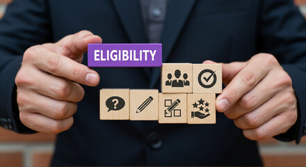 Eligibility in Hands: A person, likely a professional, holds up a block that shows ELIGIBILITY, The image symbolizes decision-making in workplace environment.