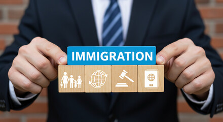 Immigration concept with wooden blocks: A person in a suit is holding wooden blocks with the word Immigration, family and world. It conveys the theme of immigration, related to people. 