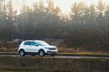 SUV on rural road with autumn trees