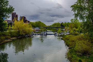 River, footbridge and park with city buildings in Calgary