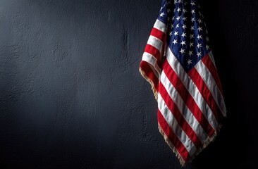 Worn and weathered national banner hangs against a dark background, with stars and stripes visible
