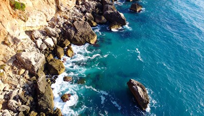 Aerial view of rocky coastline with turquoise water and cliffs.