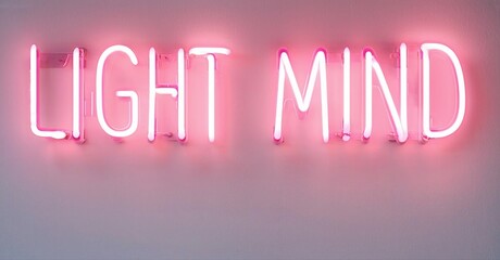 Obraz premium Pink neon sign displays words Light Mind. Simple background provides contrast. Bright illumination creates visual impact.