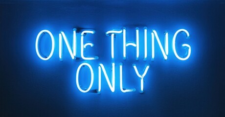 Bright neon sign displays text one thing only. Blue glow contrasts dark background. Simple, modern aesthetic. Minimalist design.