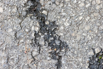 Road damage: Detailed view of brittle asphalt with cracking
