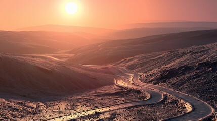 A sunlit, winding road traverses a valley between snow-dusted mountains at sunset