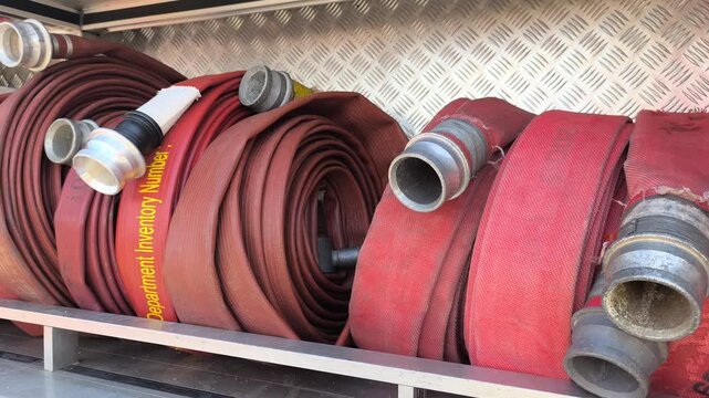 Rolled fire hoses stored inside a fire truck. These tools are ready for emergency response. They are designed to withstand and deliver high-pressure water flow.