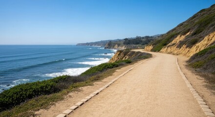 Obraz premium Coastal path winds along a cliff overlooking a vast ocean