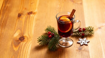 Mulled Wine with Orange and Cinnamon Sticks and Christmas decoration on wooden table. Copy space