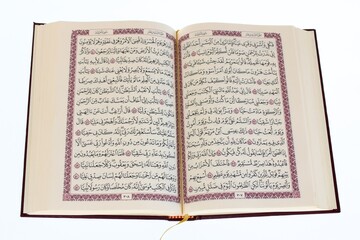 Obraz premium Open Holy Quran book with Arabic calligraphy isolated on white background top view