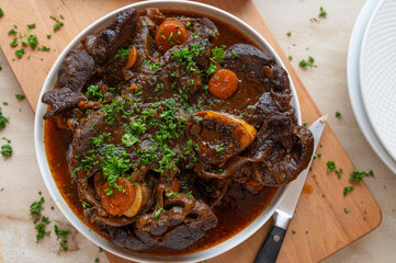 Homemade fresh cooked braised beef shanks with gravy on a platter in the kitchen