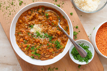 Red lentil stew with minced meat, tomatoes, carrots, celery, onions an garlic. Topped with parmesan cheese