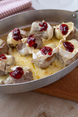 Baked pork tenderloin with camembert and cranberries in a baking dish fresh and homemade cooked