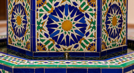 Obraz premium Exquisite Moroccan Mosaic Fountain Showcasing Intricate Geometric Patterns, Vibrant Blue, Green, and Yellow Tiles, Reflecting Traditional Islamic Artistry and Cultural Craftsmanship