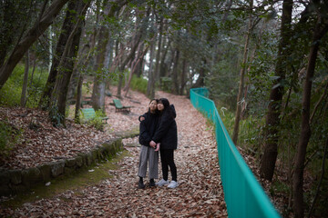 冬の朝の公園で楽しく散歩しながら遊んでいる女子中学生姉妹の姿