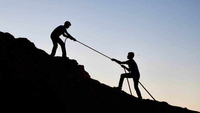 Person Helping Another Up with Rope Symbolizing Support