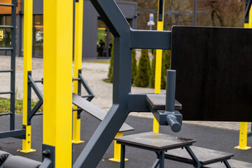 Fitness equipment is set up in a public area with workout stations and open spaces for exercise activities in daylight