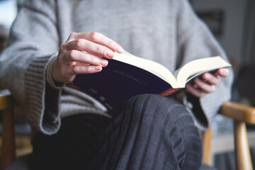 Close-up of a woman opening a book and reading.