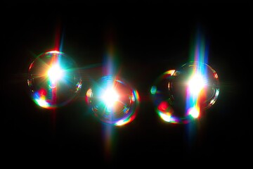 Close-up of four translucent spheres, brightly lit with iridescent hues against black