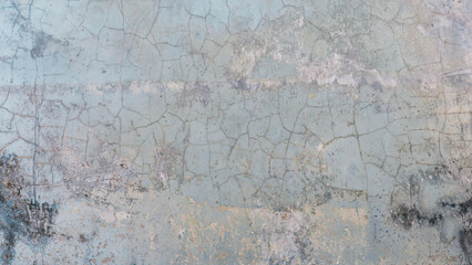 Distressed pale blue concrete wall texture with heavy cracks and weathering.