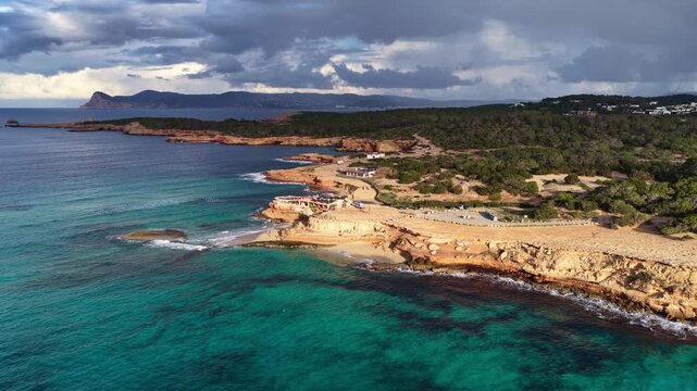 Beautiful idyllic Ibiza beach near Cala Hort, drone view of Ibiza coastline, Balearic Islands, Spain. Aerial shot of Ibiza coast with crystal clear turquoise waters, vacation on Ibiza island. 