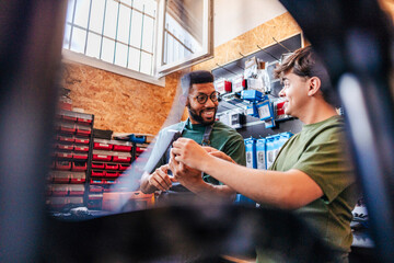 Two men discussing bike parts at workshop
