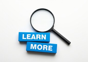 Magnifying glass with blue wooden blocks written learn more.
