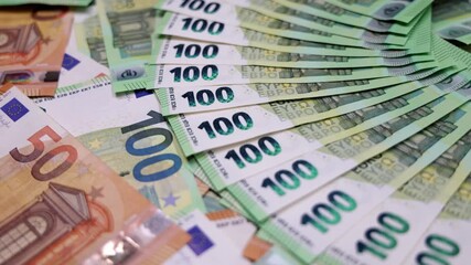 Stacks of euro banknotes are arranged in a fanned-out display showcasing various denominations, highlighting the intricate designs and vibrant colors of the currency - Powered by Adobe