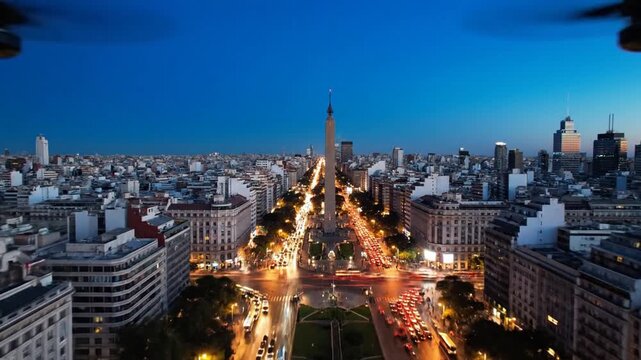 Aerial view of Buenos Aires Obelisco at dusk with traffic lights and city skyline.
