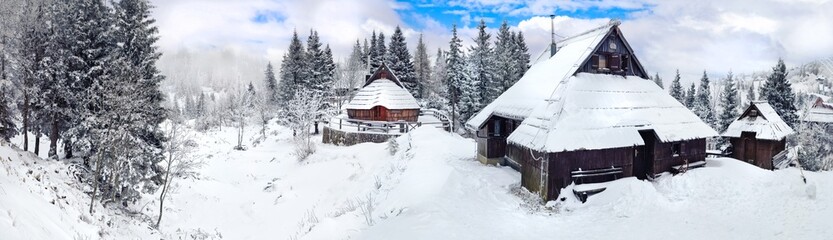 Traditional wooden huts on a snow-covered mountain plateau Velika Planina, Slovenia , panoramic view. Winter scenery high resolution panorama