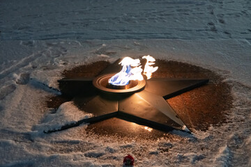 Obraz premium The Victory Monument and the eternal flame with carnations, a symbol of victory over fascism and May. Eternal flame. The Tomb of the Unknown Soldier. War memorial. Smolensk is a hero city