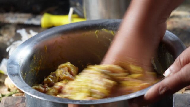 Human Hand Marinating Raw Mutton Chunks with Spices in Steel Bowl
