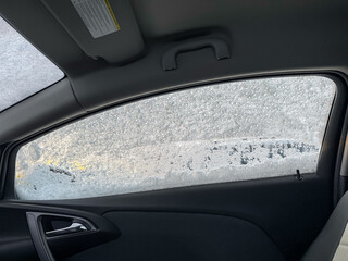 A car in the snow, snow crystals on a car in a severe frost. Winter landscape, frost. Car windows freezing during the winter season close-up. Snow Covered Car on the Street. Winter urban scene. 