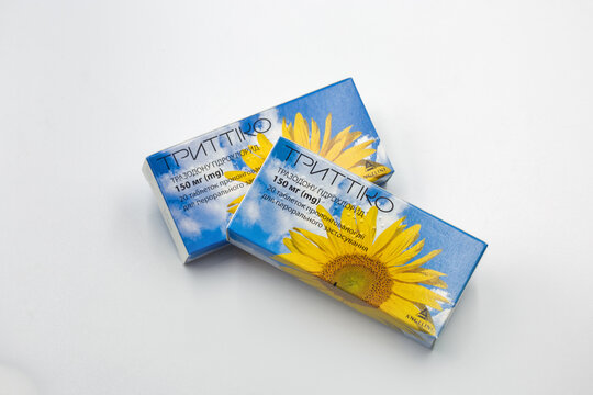 Trittiko medication boxes with sunflower design packaging closeup on white.