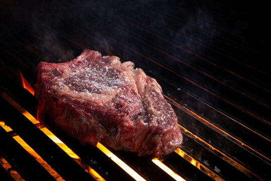 Carne sobre la parrilla con fuego y carb&oacute;n.