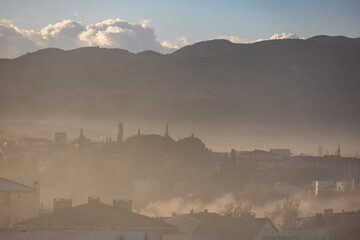 Misty small town landscape in Canakkale Turkey with layered hills and soft morning fog creating a calm atmospheric scene
