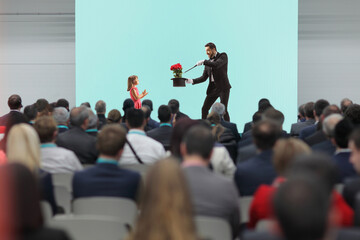 Obraz premium Girl giving applause to a magician performing a trick on stage