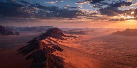 Stunning aerial view of a desert landscape at sunrise, with layered mountains and a hazy atmosphere