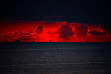 朝の海の水平線の船影と朝焼けの赤い空と雲20211205