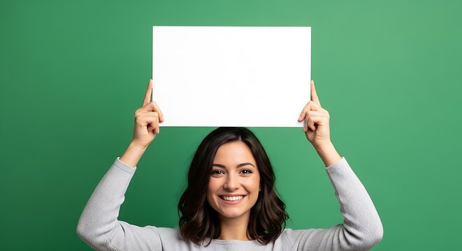 Smiling Woman Holding Blank Sign Above Head on Green Background.