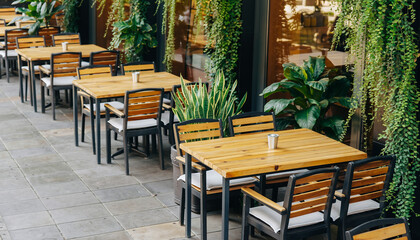 Photorealistic outdoor coffee shop design, wooden tables and chairs, green plants, natural daylight, cozy atmosphere, clean composition, copy space, ultra-detailed.