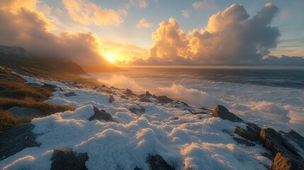 Breathtaking sunset over a snowy coastline with dramatic clouds and ocean waves