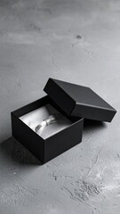Open black box, white silk inside. Gray textured surface