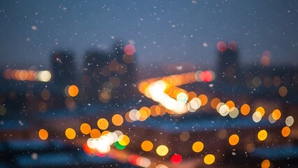Blurred nighttime cityscape with falling snowflakes and warm glowing bokeh lights creating a magical winter season background