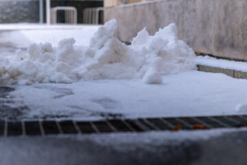 Snow blankets the ground, creating a serene winter landscape in a quiet urban space