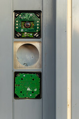 Intricate details of a circuit board mounted on a metal panel outdoors during golden hour light